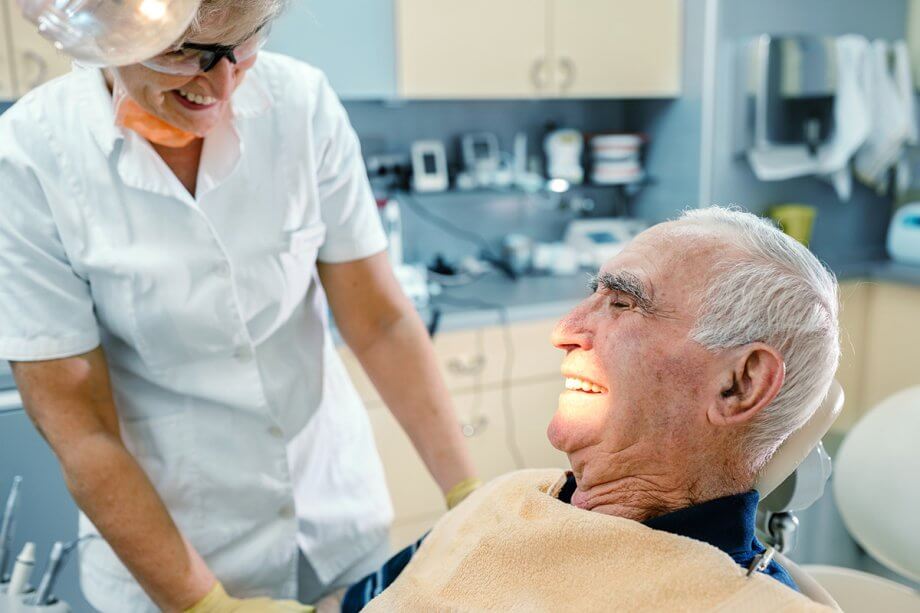 an older man smiles in a dental chair