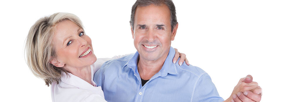 older couple holding hands, dancing and smiling