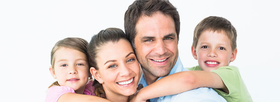 smiling family with husband and wife and young boy and girl